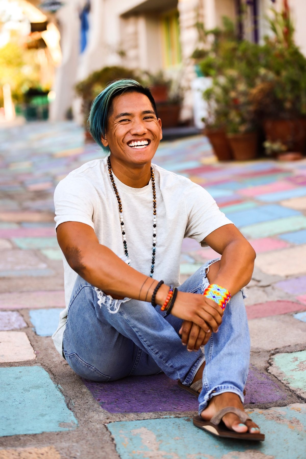 Ryan smiling, sitting on a painted street